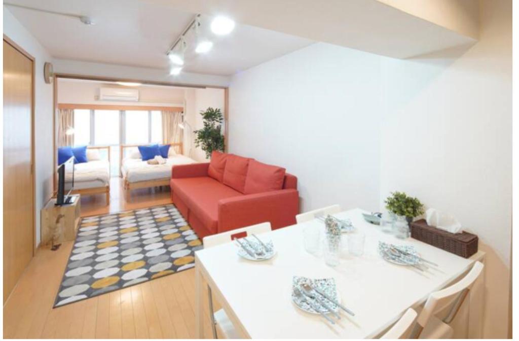 - un salon avec une chaise rouge et un canapé dans l'établissement 【Shinjuku33】光回線完備パーティースペースにも使える新宿のお部屋, à Tokyo