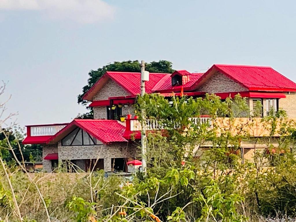Viva Villa في Jhājra: منزل على سطوح حمراء فوق تلة