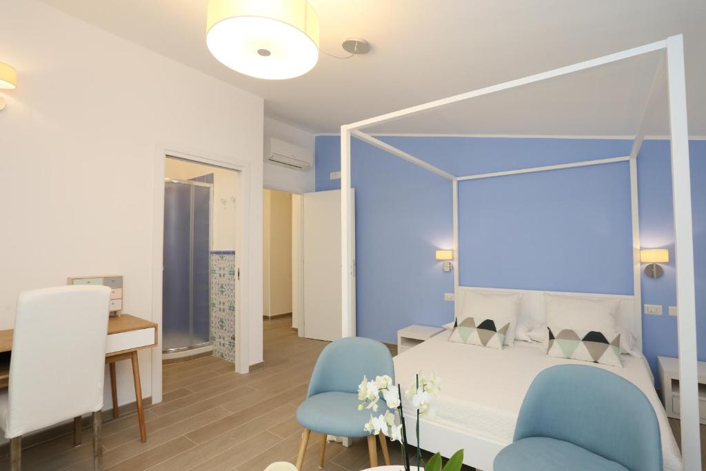 a bedroom with a bed and two blue chairs at Bed and Breakfast Country Cottage in Civitavecchia