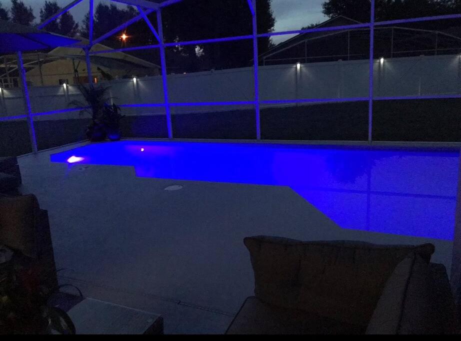 - une piscine éclairée en bleu la nuit dans l'établissement Pool heater, Huge yard, bbq grill ,5 bedroom3 bath WIFI, 15 min from disney, Walmart 4 min, all restaurants close to the house, à Orlando