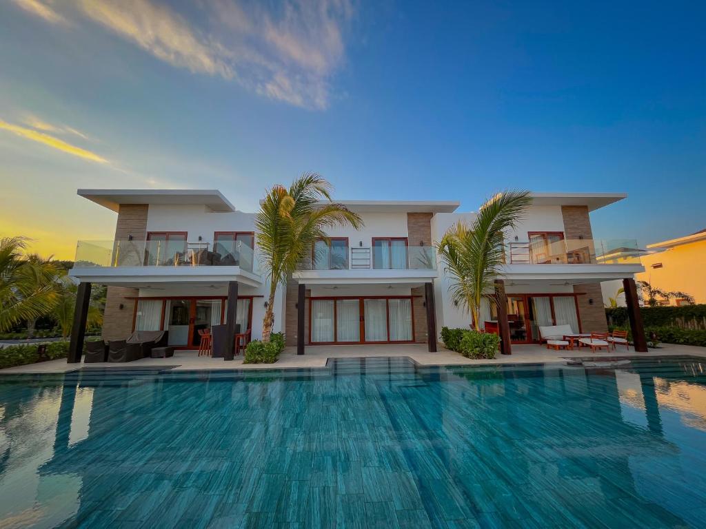 a house with a swimming pool in front of it at Villas La Mar in Monterrico