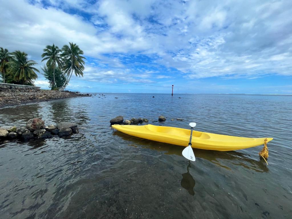 a yellow boat sitting in the water next to a beach at Tahiti - Kea Lodge in Papara