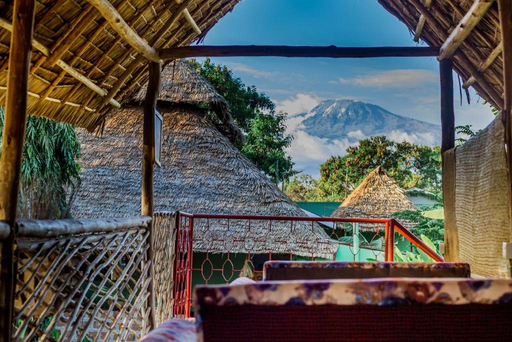 a view of a mountain from a straw hut at Royal Wonders Hotel in Moshi