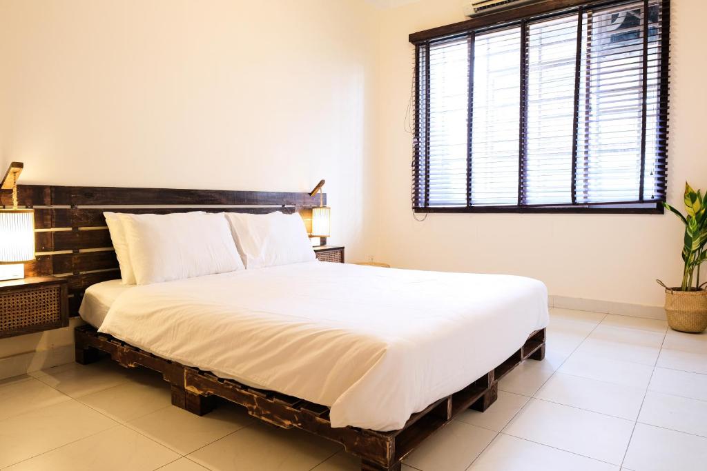 a bedroom with a large bed with a wooden headboard at Mao Home in Ho Chi Minh City