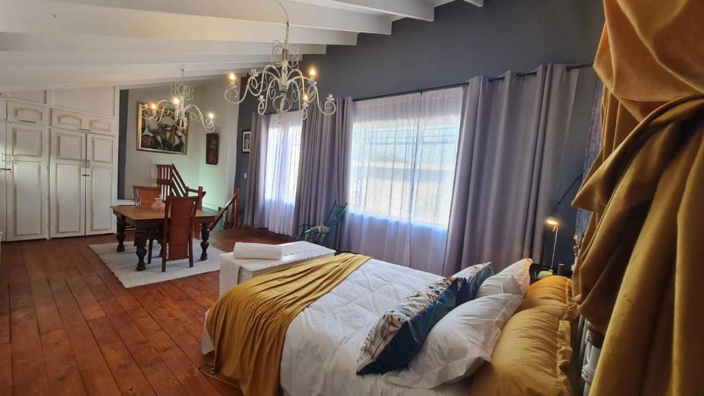 1 dormitorio con 1 cama y 1 mesa en una habitación en Gadute Haven, en Pretoria