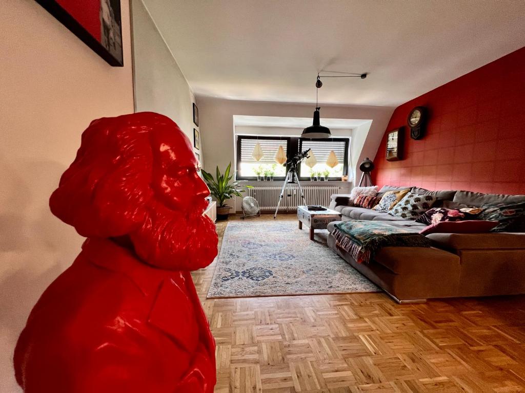 a living room with a large red sculpture of a woman at Domus Merian XII in Trier