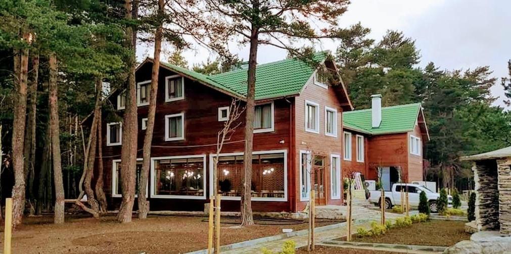 ein großes Holzhaus mit grünem Dach in der Unterkunft ADRİA ALADAĞ-GOLCÜK in Seben