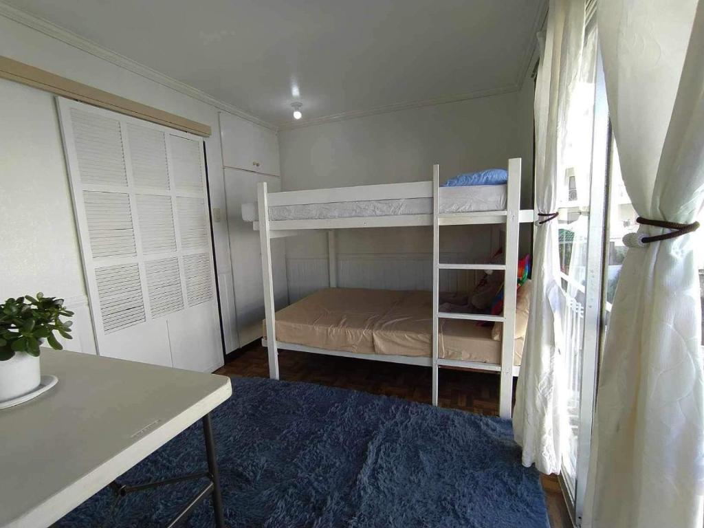 a small bedroom with a bunk bed and a desk at Green Valley Condo with View in Baguio