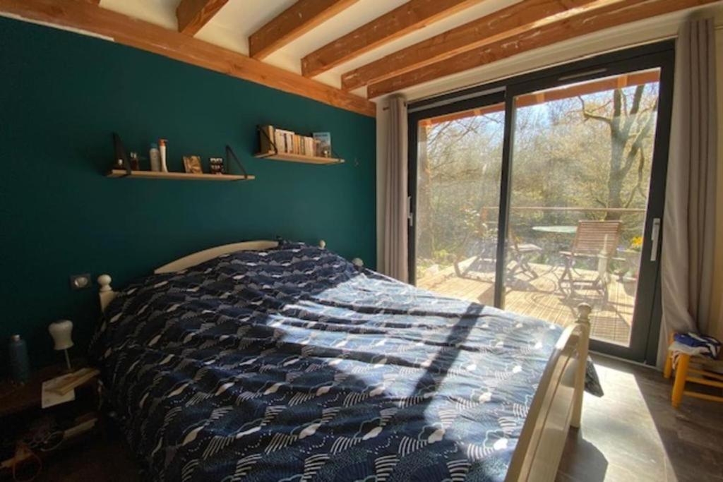 a bedroom with a bed and a large window at La jonquille in Gramat