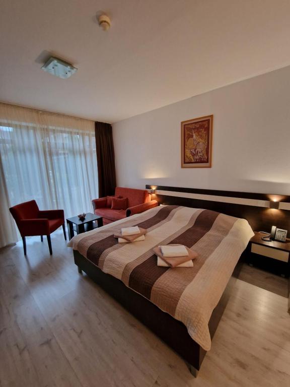ein Schlafzimmer mit einem großen Bett und einem roten Stuhl in der Unterkunft Apartmán ELIZABETH in Bešeňová
