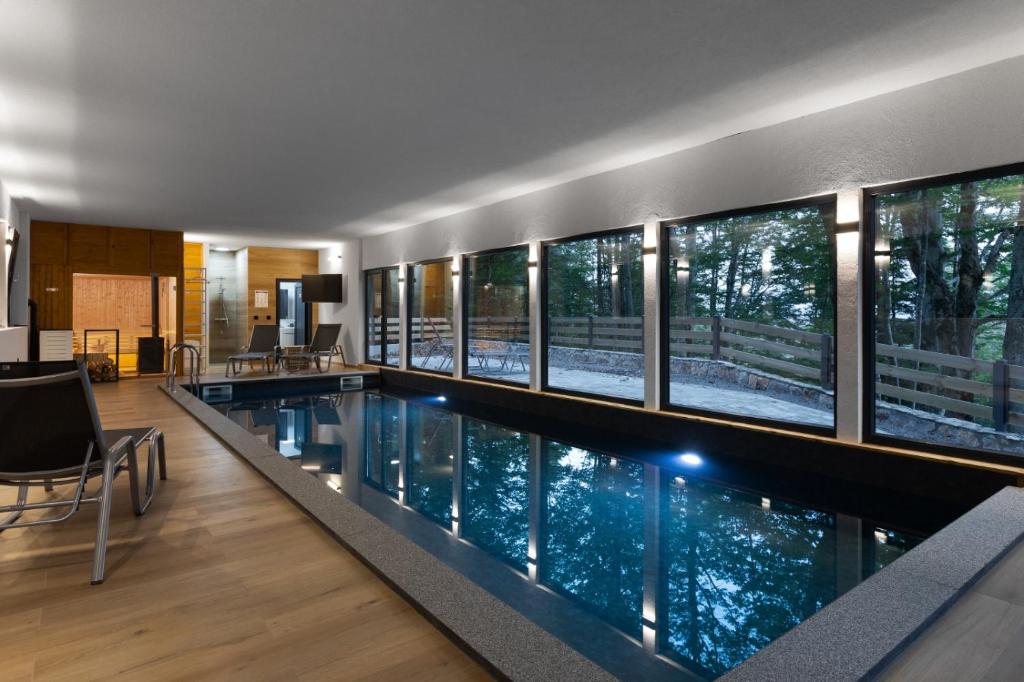 einen Infinity-Pool in einem Haus mit Fenstern in der Unterkunft forest angel rg in Ravna Gora
