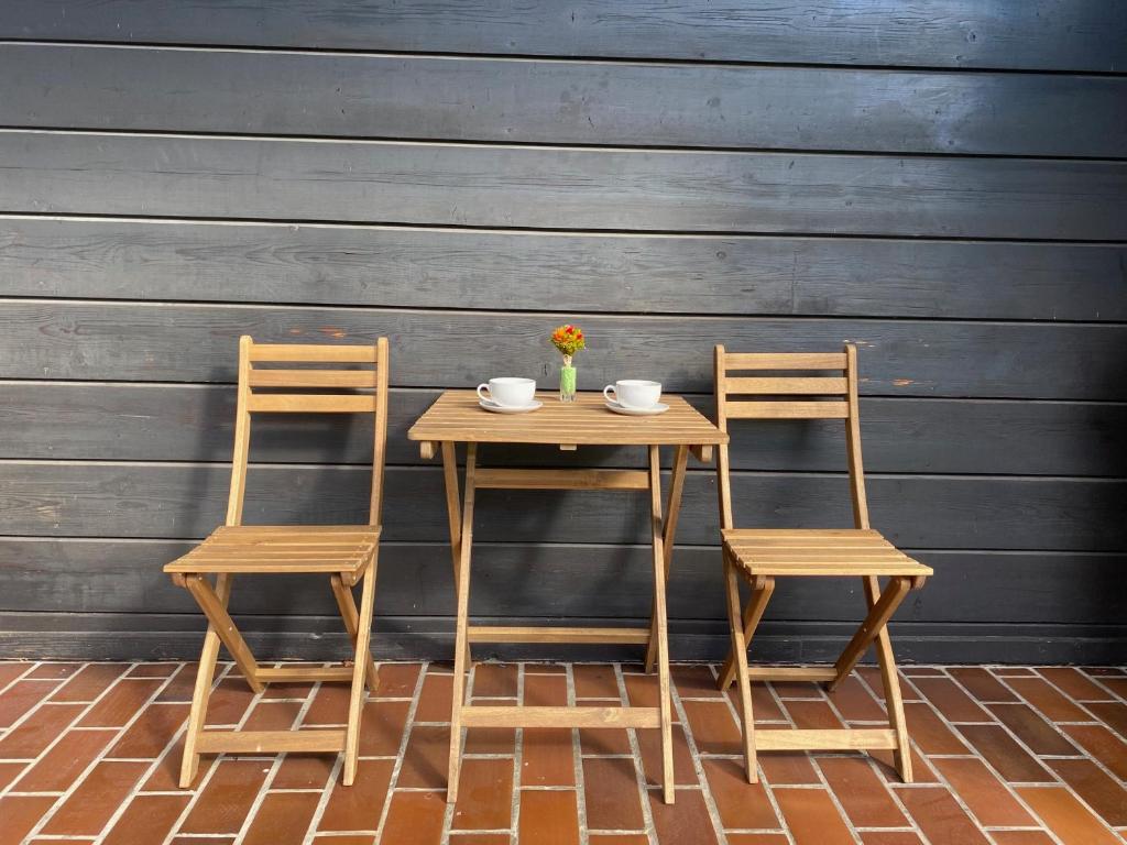 een houten tafel en twee stoelen naast een muur bij Apartma Iskra in Podčetrtek