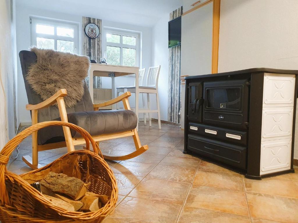 a living room with a chair and a tv at Rittergut Dornreichenbach 