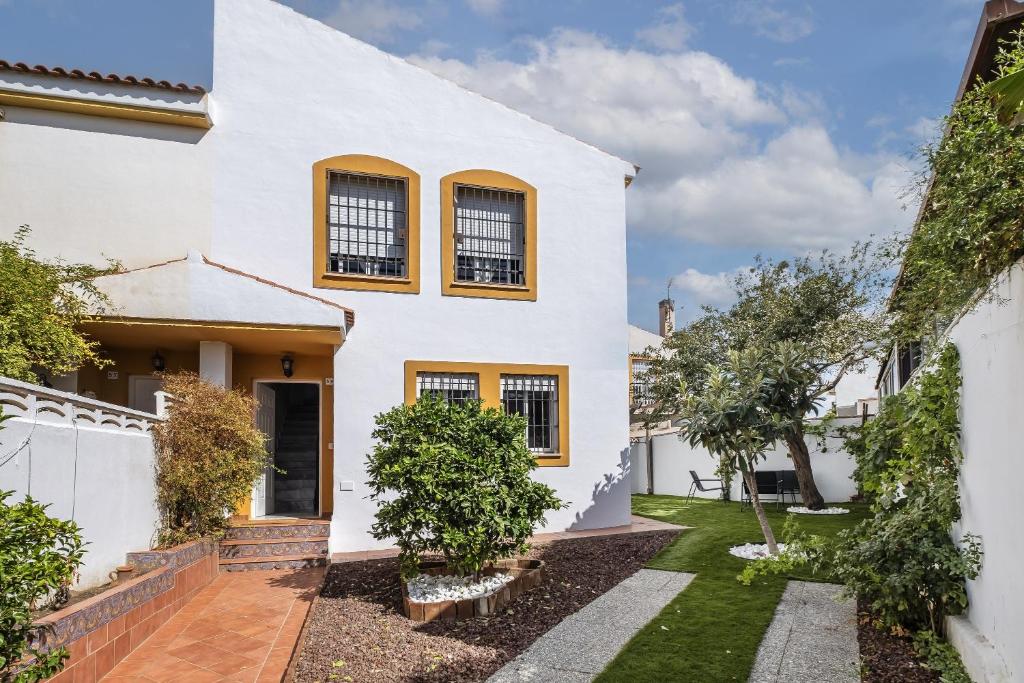 biały dom z dziedzińcem i drzewami w obiekcie Brisa del mar w mieście Chilches