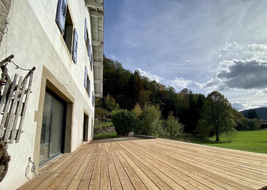 una terraza de madera en el lateral de un edificio en LE GITE DES ABEILLES, en Rupt-sur-Moselle