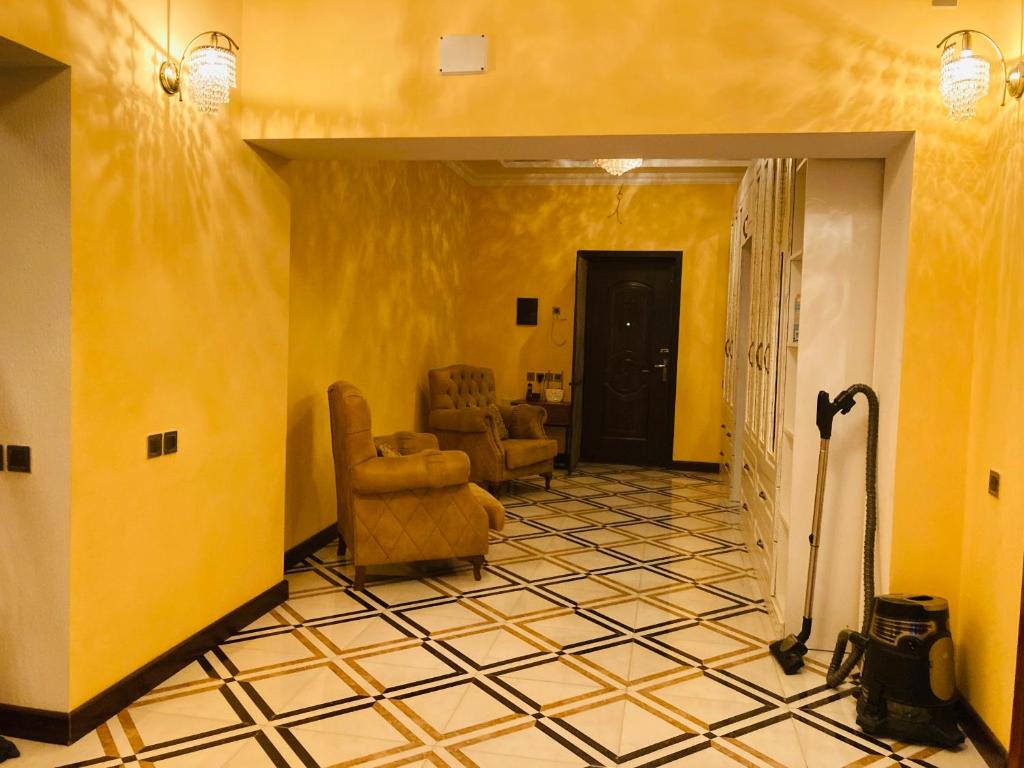 un soggiorno con pareti gialle e pavimento piastrellato di Вилла Эмин a Baku