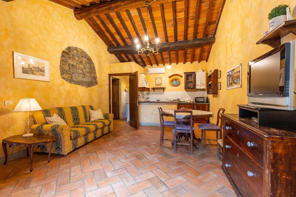een woonkamer met een bank en een tafel bij Borgo Dolci Colline Resort Loggia in Castiglion Fiorentino