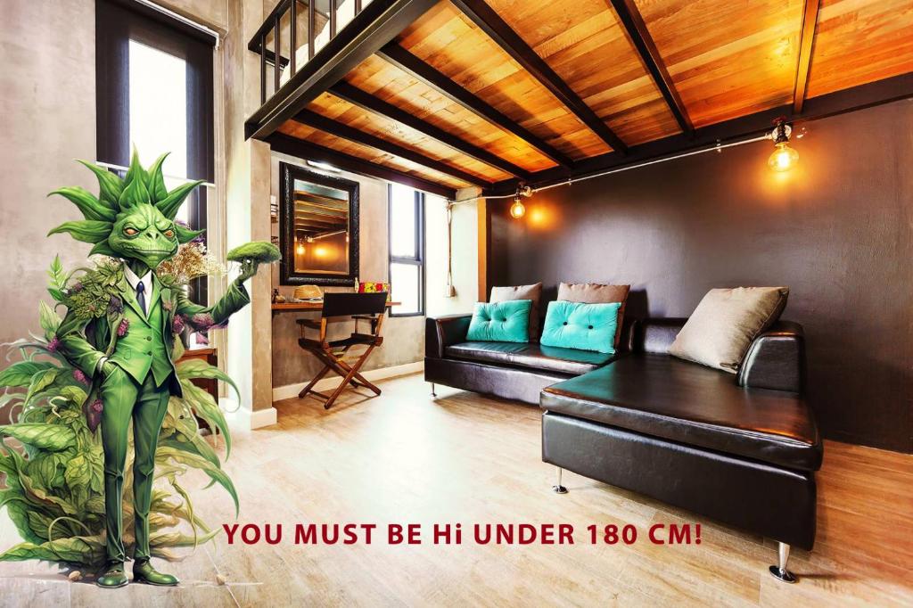 A loft-style lounge with a black sectional sofa, wood ceiling and a playful dog-themed figure.