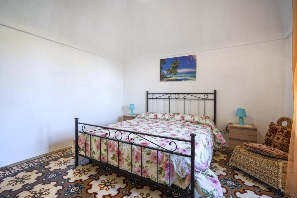 um quarto com uma cama e uma cadeira em La casa di pietra location Rosy em Monopoli