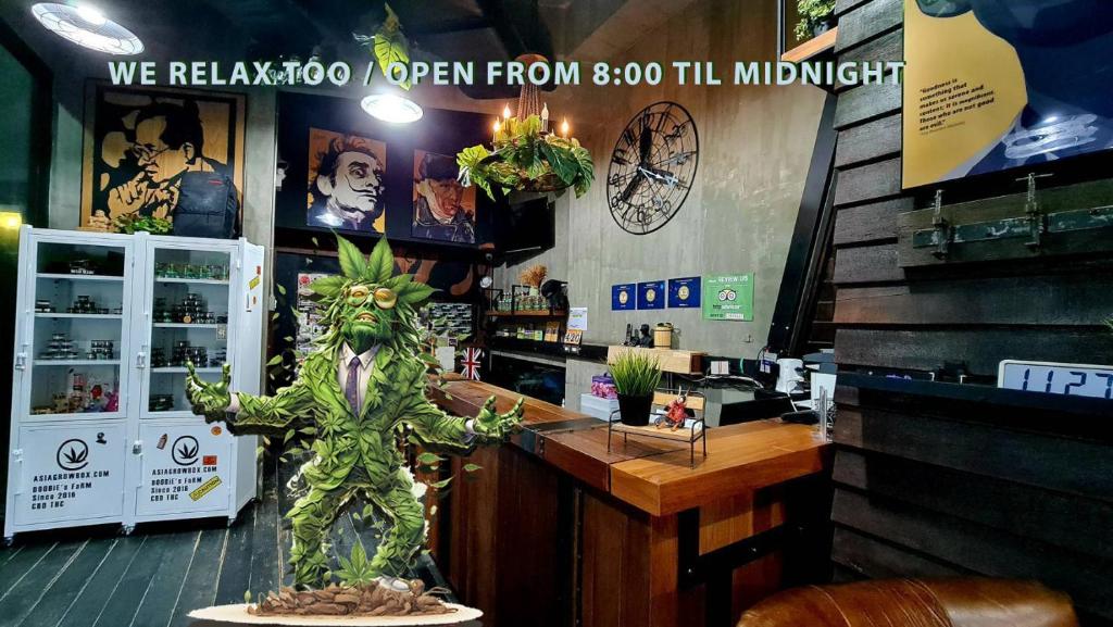 A themed bar counter with refrigerators, artwork, and a large decorative plant character.