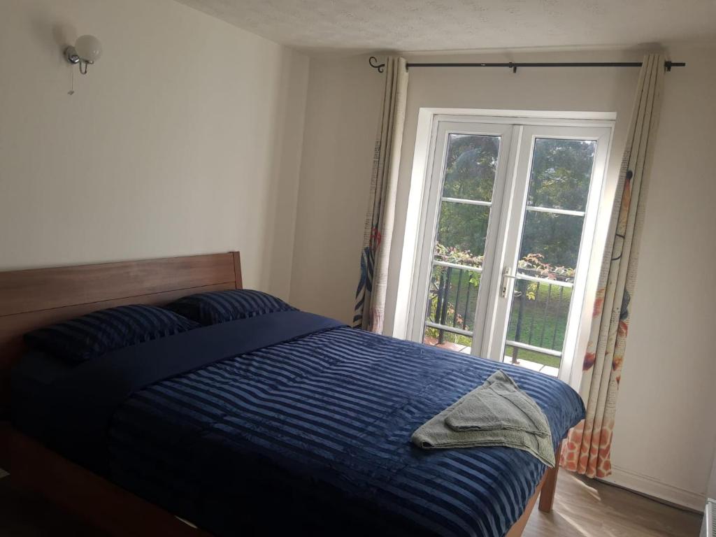 ein Schlafzimmer mit einem blauen Bett und einem Fenster in der Unterkunft Rahal Concord in London