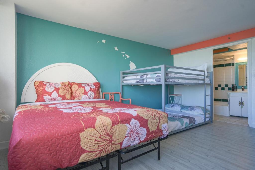 a bedroom with a bed and two bunk beds at Diamond, Ocean, and Canal view Affordable Family House in Honolulu