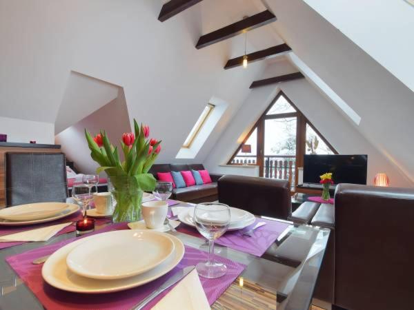 a dining room with a table with plates and wine glasses at Apartament Pod Giewontem in Zakopane