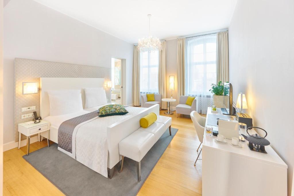 - une chambre avec un grand lit et un salon dans l'établissement Hotel Ketschauer Hof, à Deidesheim