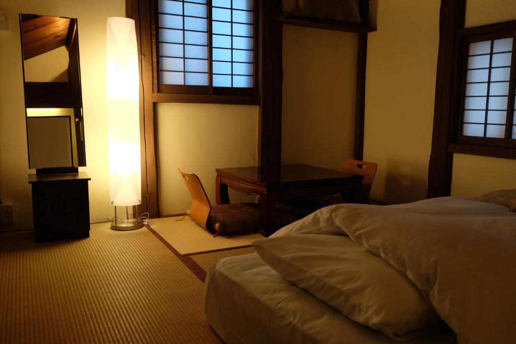 Postel nebo postele na pokoji v ubytování Toshiharu Ryokan