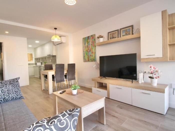 a living room with a couch and a table with a television at APARTBEACH EUROPEOS 2 MUY LUMINOSO y GRAN TERRAZA in La Pineda