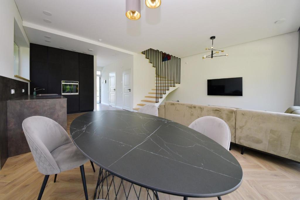 考納斯的住宿－MG - Namai，厨房以及带黑色桌椅的用餐室。