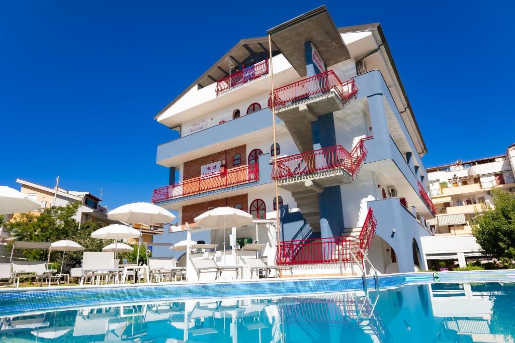 um hotel com piscina em frente a um edifício em Hotel Alexander em Giardini Naxos