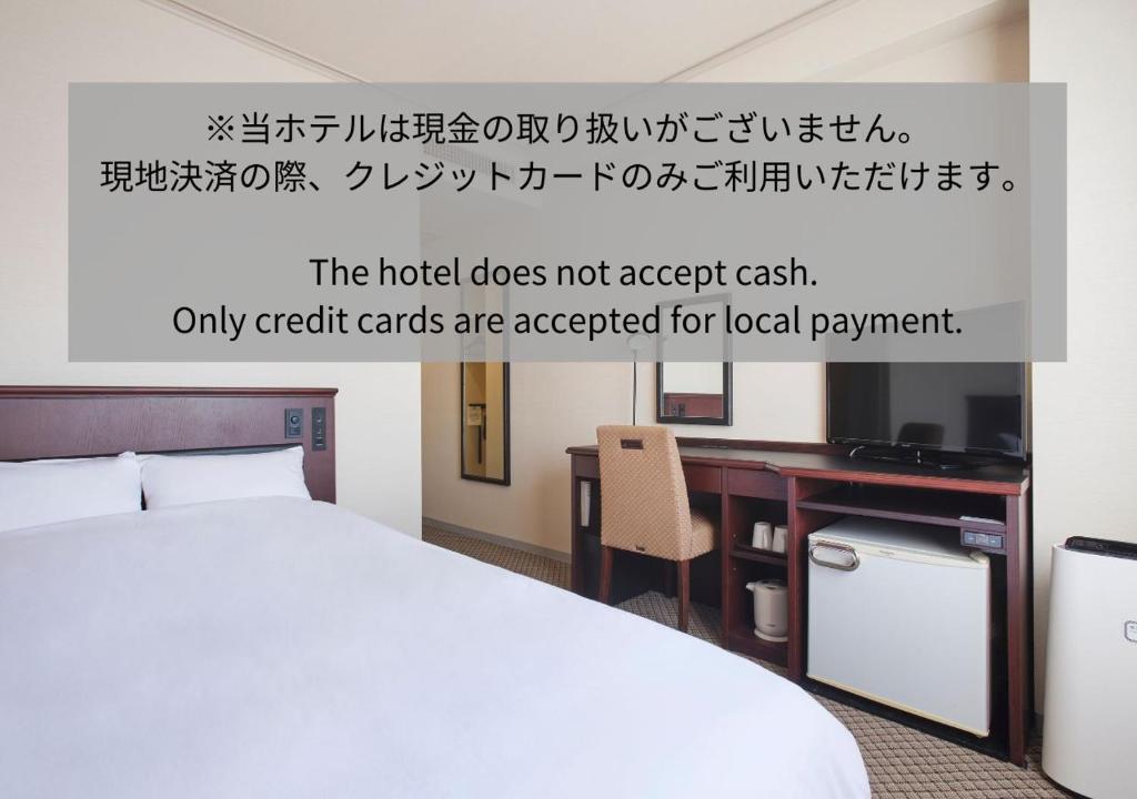 um quarto de hotel com uma cama e uma televisão em 高松パークホテル em Takamatsu