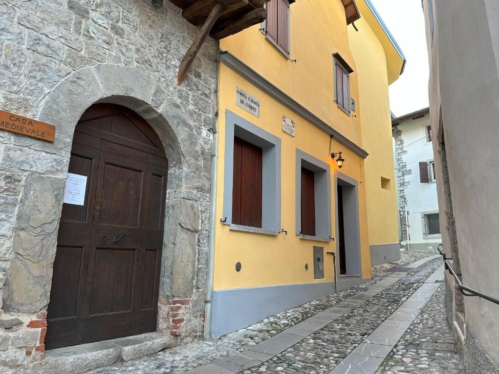 un edificio con una puerta marrón en una calle en Alla Casa Medievale, en Cividale del Friuli