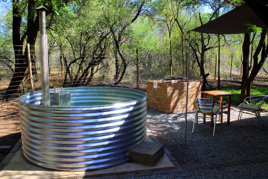 una grande vasca di metallo con tavolo e sedia di Ndlovu Tiny Home Dinokeng a Klipdrift