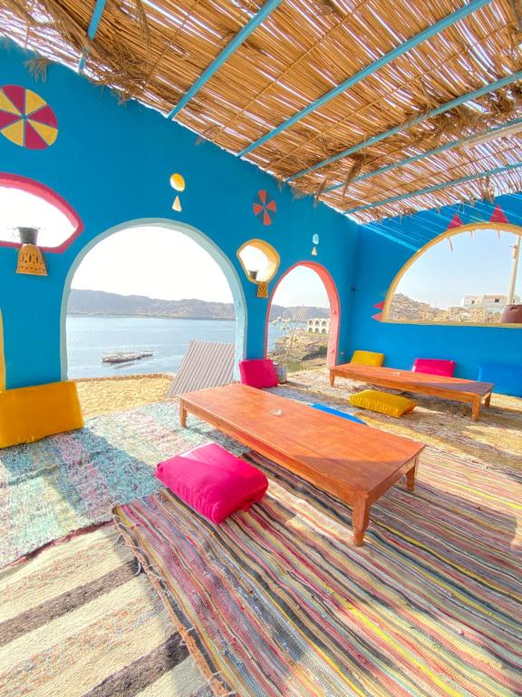 een woonkamer met een tafel en twee banken bij Heissa Hostel in Aswan