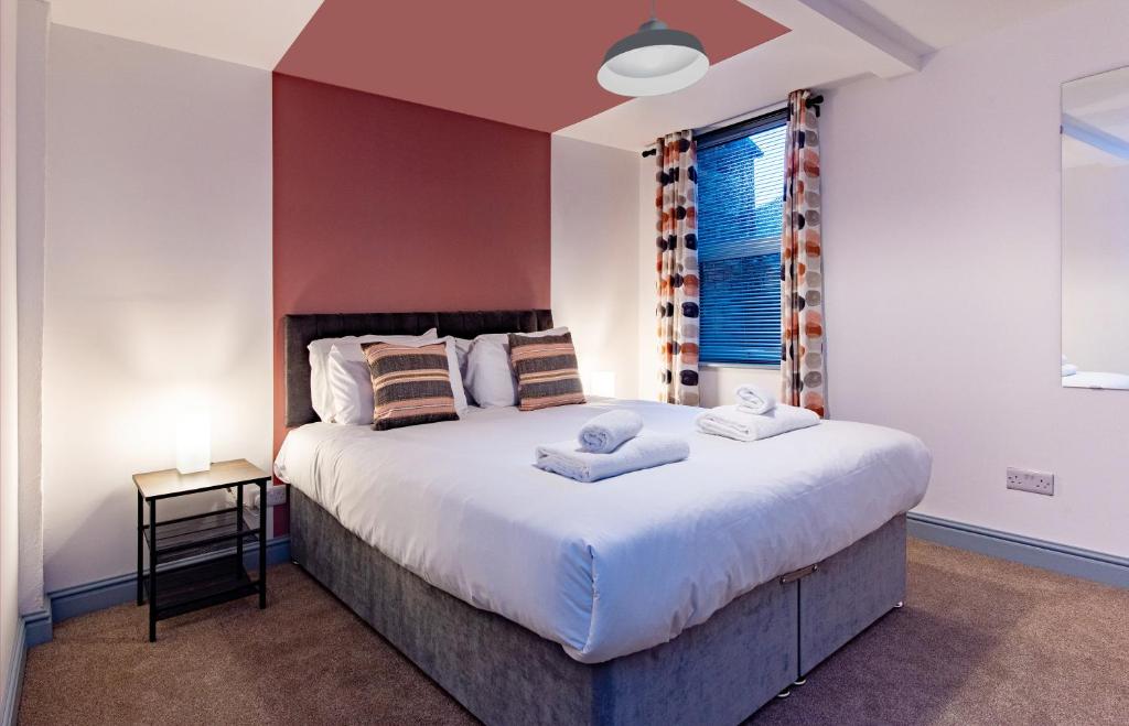 een slaapkamer met een groot bed en een raam bij Newark Apartments: Ideal for Contractors with Parking in Balderton