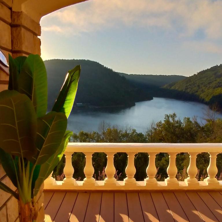a balcony with a view of a lake at Ma villa au bord de l'eau in Miremont
