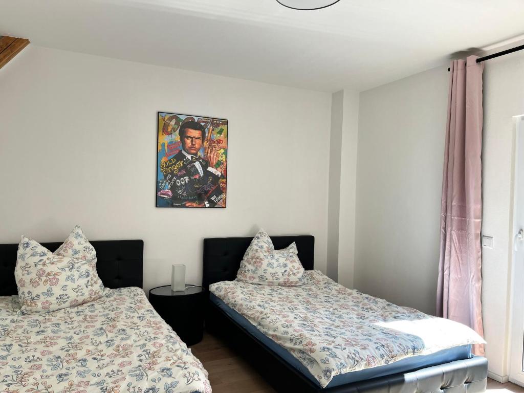 a bedroom with two beds and a painting on the wall at Frisch freche 3 R Ferienwohnung in Dohna