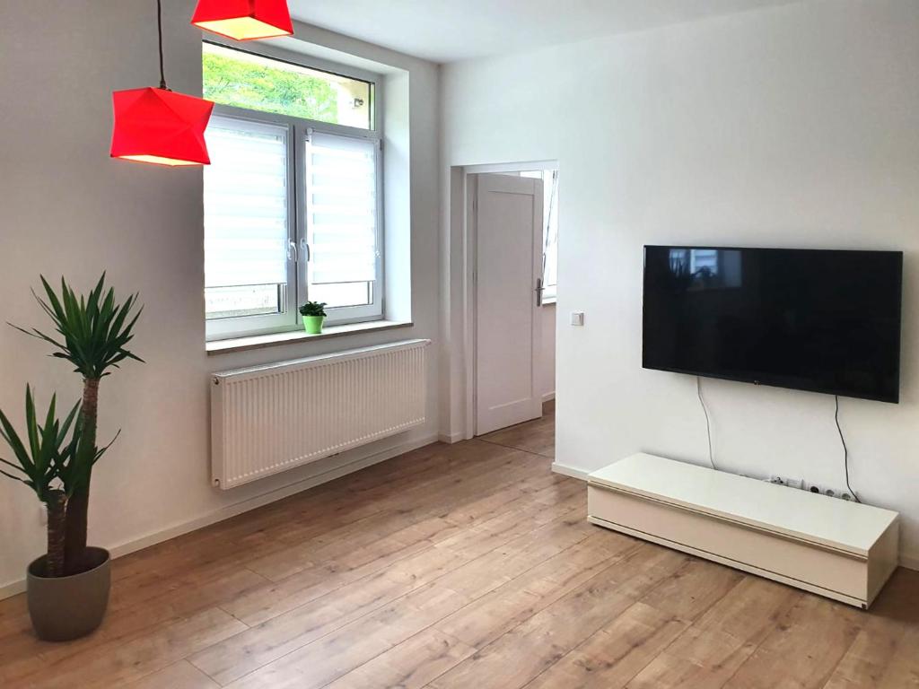 a living room with a flat screen tv on a wall at Geräumige moderne 3 Raumwohnung in Dohna