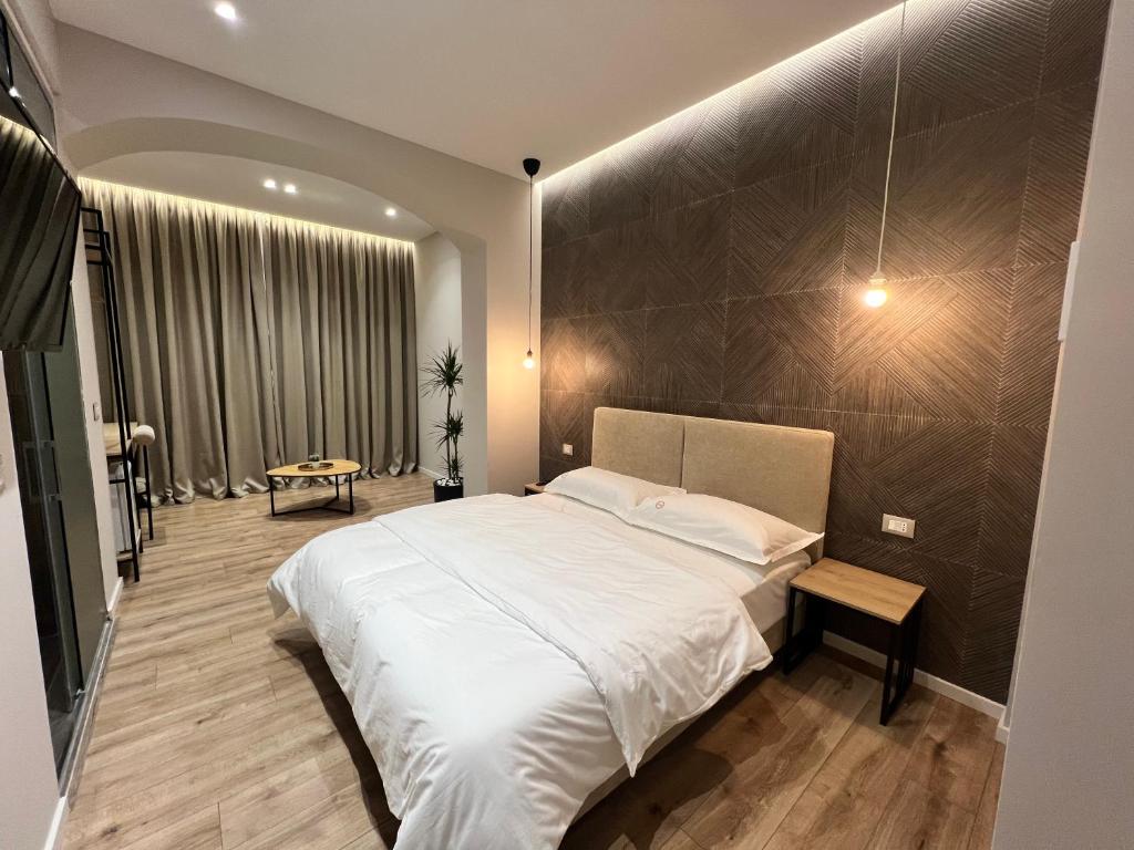1 dormitorio con cama grande y ventana grande en D Rooms en Tirana