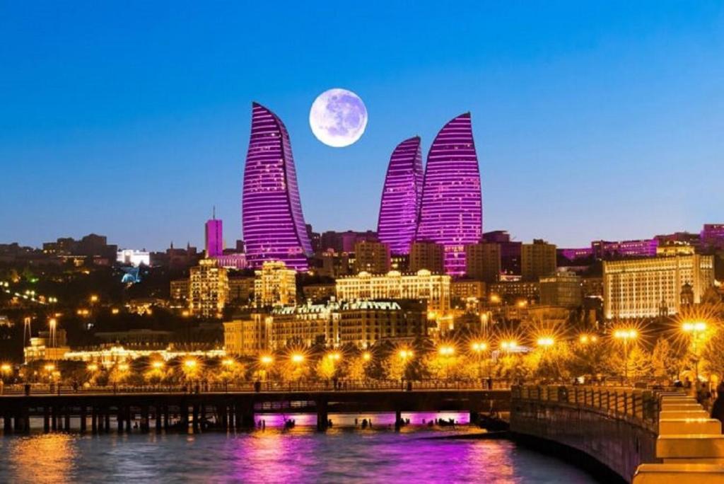 a view of a city with the moon in the sky at Cityland Hotel Baku in Baku