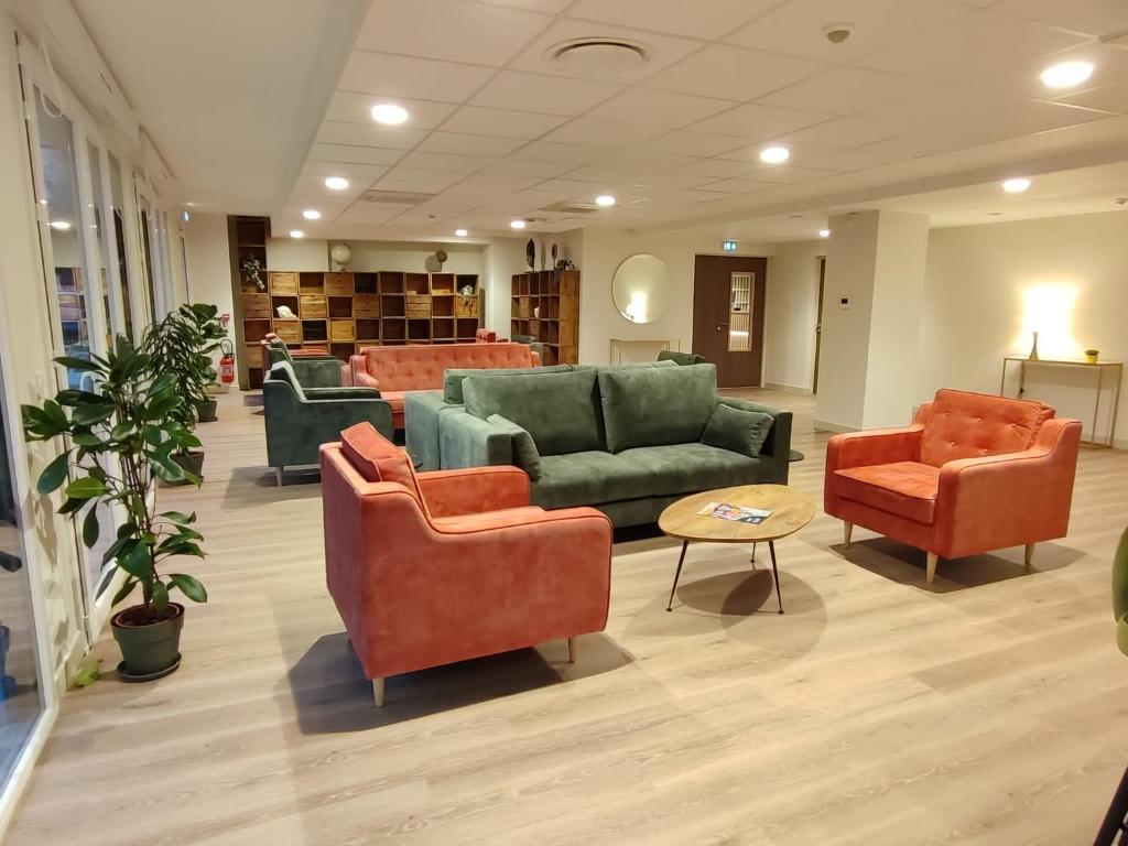 - un hall avec des canapés et des chaises dans une bibliothèque dans l'établissement Zenao Appart'hôtels Montivilliers, à Montivilliers