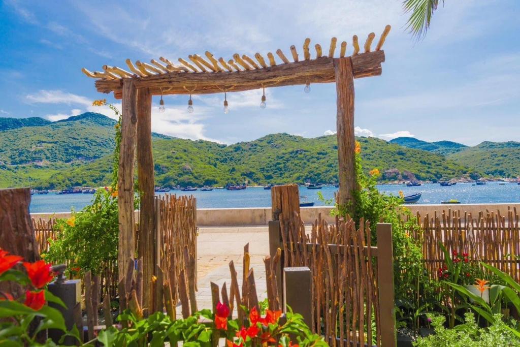 ビンヒーにあるLa Mer - Vĩnh Hy bay - beachfront villa CHÀIの海岸の木のアーチのある木製の柵