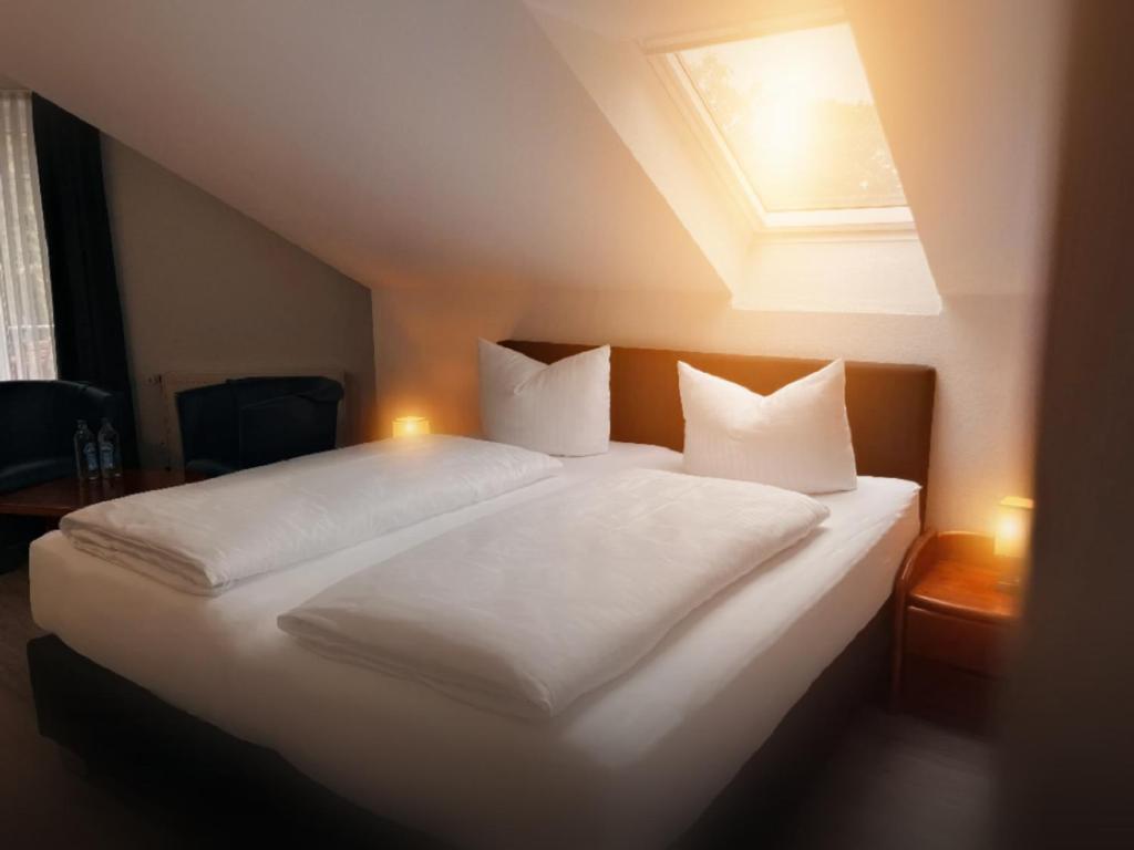 リンゲンにあるAppart-Haus Business Apartmentsのベッドルーム1室(大型ベッド1台、白いシーツ、枕付)