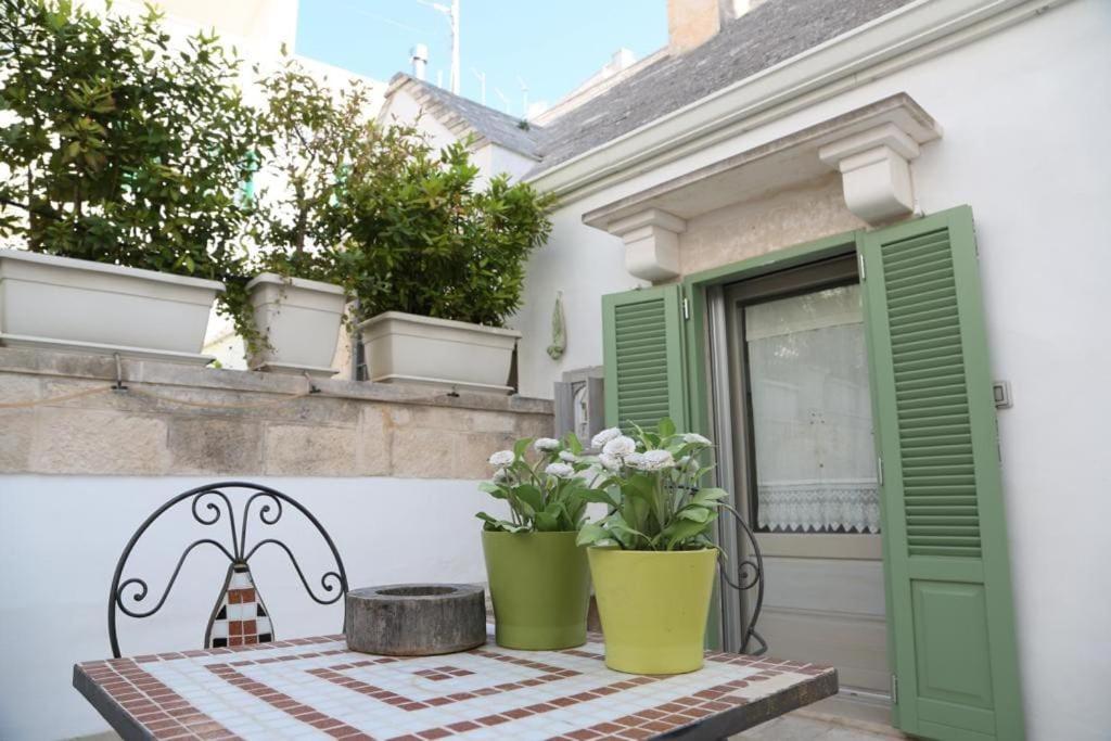 une table avec deux vases verts sur une terrasse dans l'établissement Cummersa, à Locorotondo