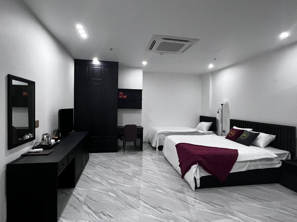 een hotelkamer met 2 bedden en een televisie bij GOLDEN JOY HOTEL & APARTMENT in Hai Phong
