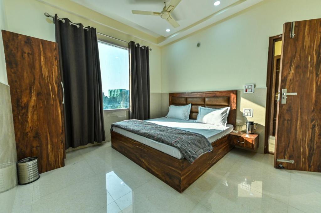 a bedroom with a bed and a large window at Royal Inn in Jammu