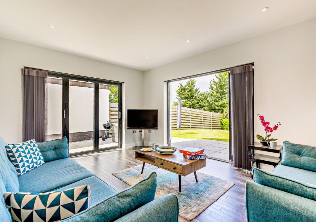 sala de estar con sofás azules y TV en Kieton Sands - Croyde en Croyde