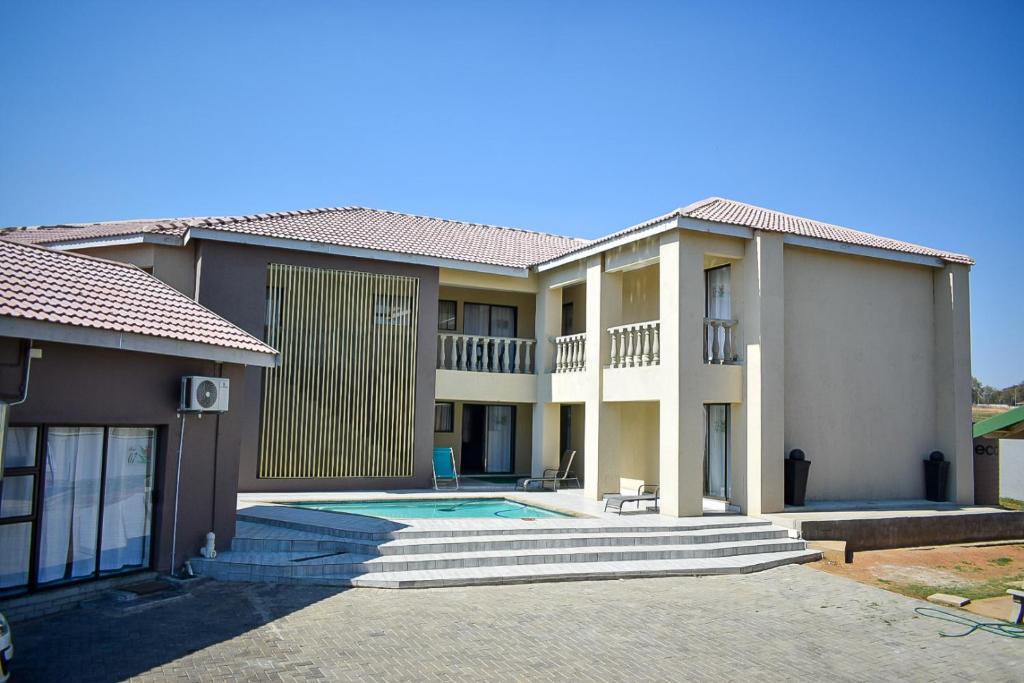 una casa con piscina frente a ella en Protea Guesthouse en Newcastle